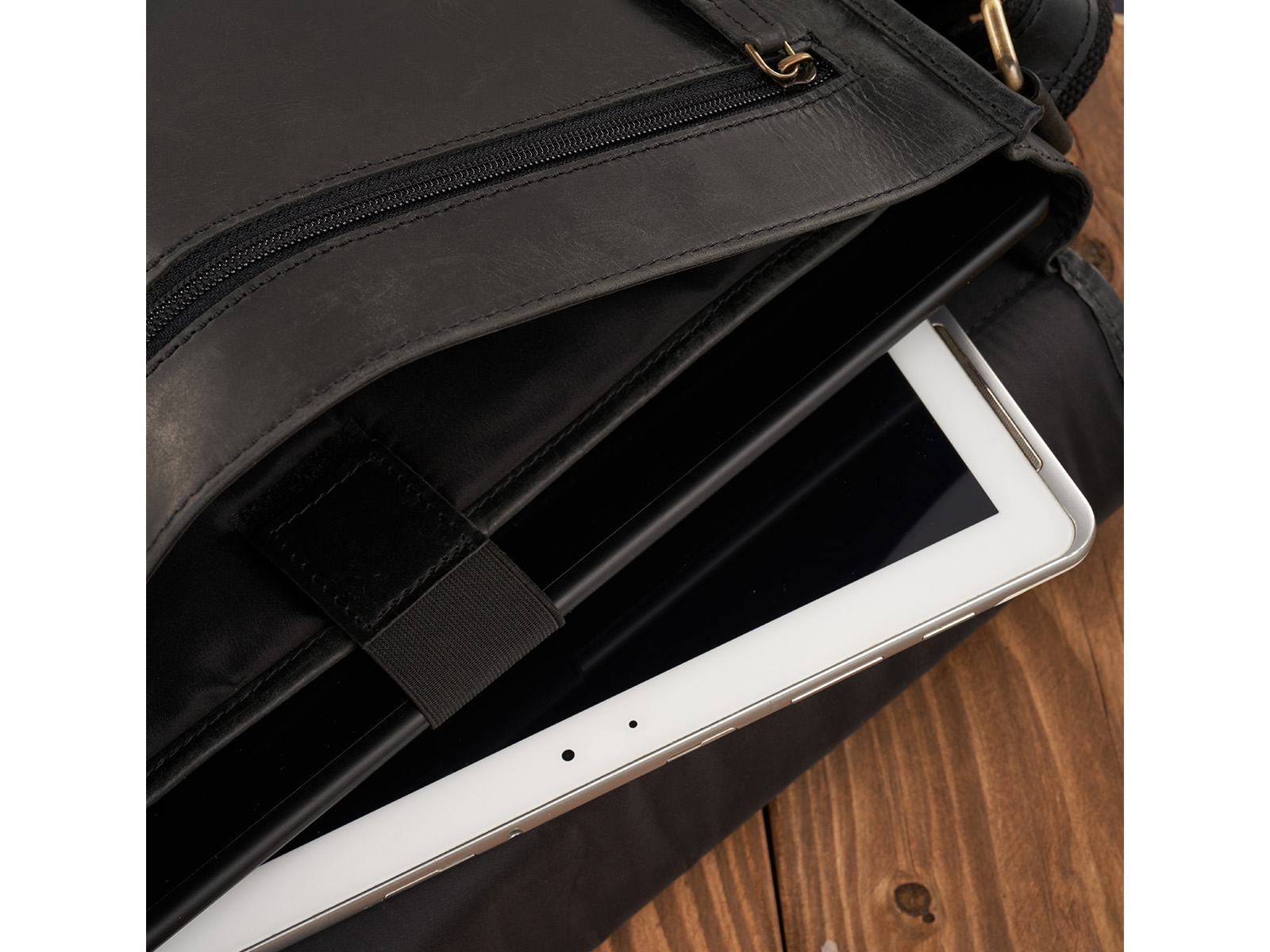 Zbliżenie na otwartą czarną skórzaną torbę męską z kieszenią na tablet