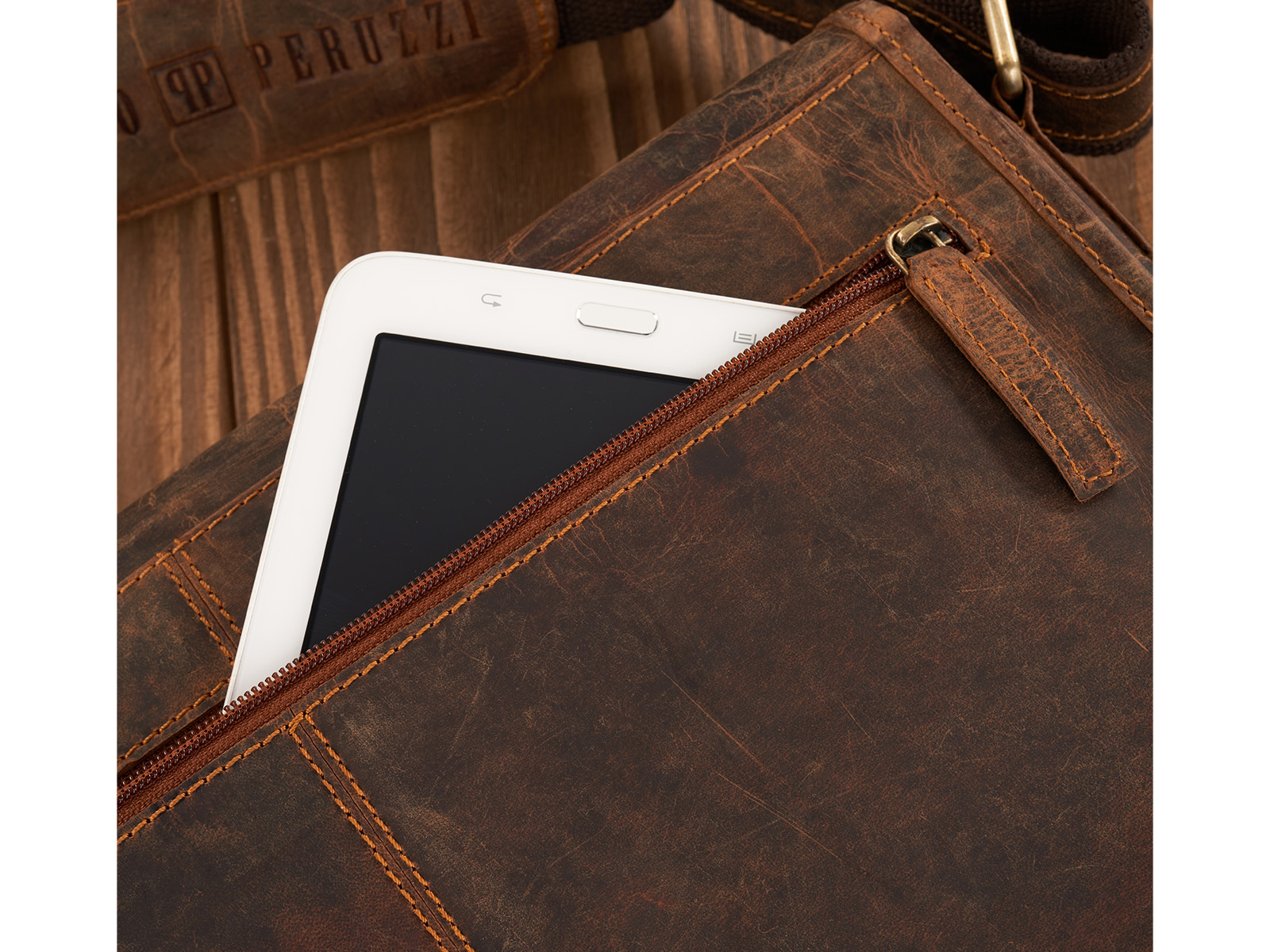 Zbliżenie na brązową skórzaną torbę vintage z kieszenią na tablet i zamkiem