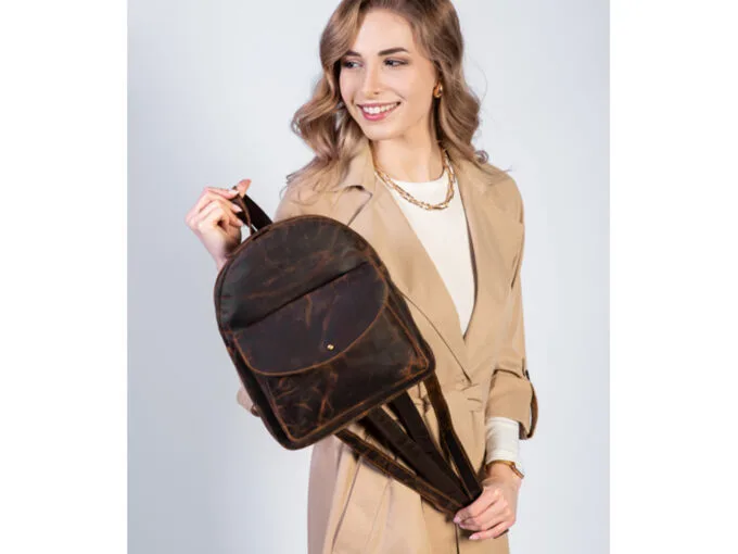 Brązowy skórzany plecak vintage z przodu, na modelce, z kieszenią i szelkami