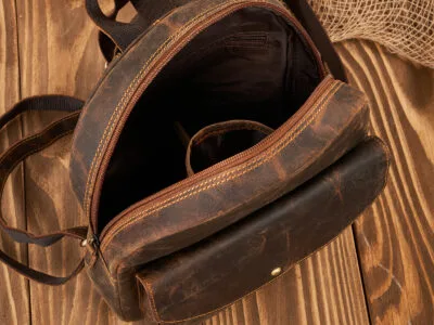 Zbliżenie otwartego brązowego plecaka skórzanego vintage z przednią kieszenią